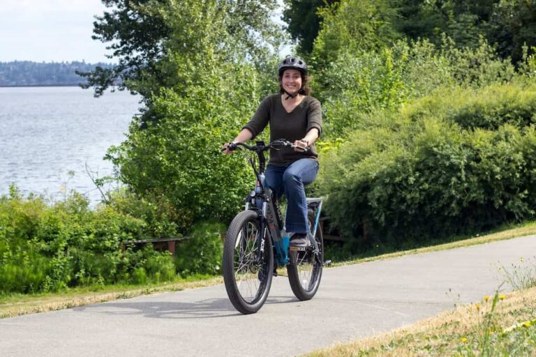 Woman riding an electric bicycle near a lake, safety emphasized by her wearing a helmet, represents the clients helped by Kevin R. Hansen, E-Bike Accident Lawyer in Las Vegas