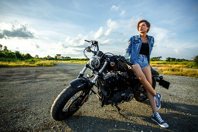 Mujer apoyada en una moto de calle aparcada en un entorno sereno al aire libre de estilo campestre, simbolizando la pasión por las motocicletas y el apoyo legal proporcionado por Kevin R. Hansen, Abogado de Accidentes de Motocicleta en Las Vegas.