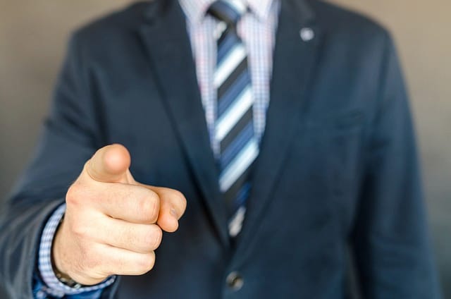 Confident man in suit pointing directly at viewer, embodying the assertive advocacy for personal injury victims by Kevin R. Hansen, Las Vegas Lawyer