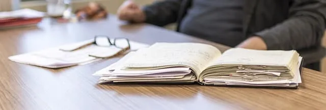 Open notebook with blurred personal injury attorney in the background, indicative of the diligent case preparation at Kevin R. Hansen's Las Vegas law firm