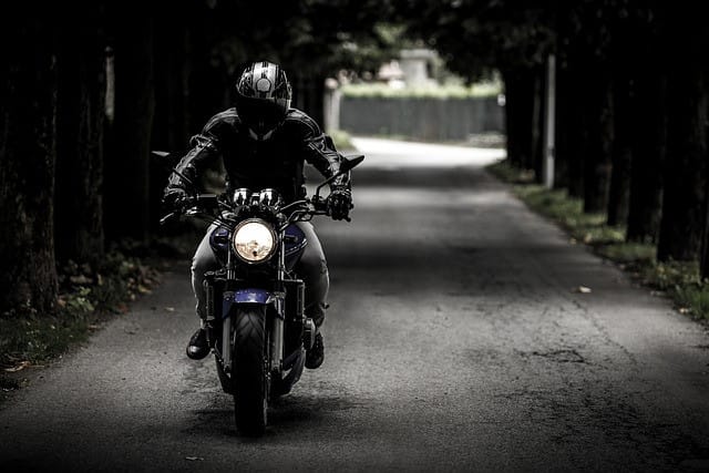 Geared-up street bike rider approaching the camera through a tunnel-like row of trees, symbolizing the resilience of motorcycle riders and the legal support provided by Kevin R. Hansen, Motorcycle Accident Lawyer in Las Vegas