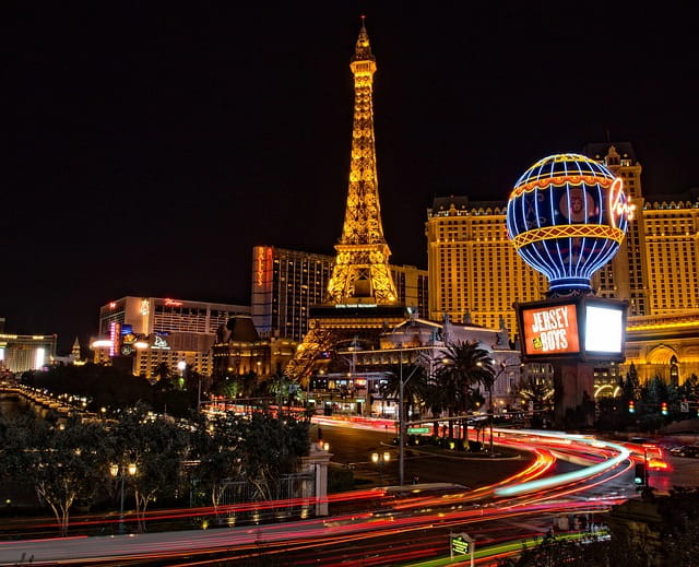 Vista nocturna del Strip de Las Vegas con el Hotel París al fondo, que encarna la brillante reputación de Kevin R. Hansen como abogado de primera línea de Las Vegas para todo tipo de casos de lesiones personales.