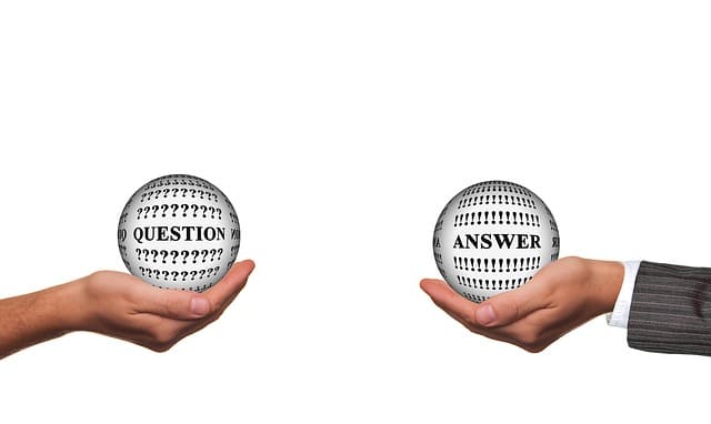 Dos manos que sostienen bolas de cristal, una con la palabra "Pregunta" y la otra con "Respuesta", simbolizando la completa sección de preguntas frecuentes del bufete de abogados de Kevin R. Hansen.