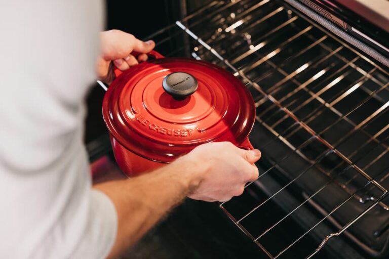 person taking hot dish from oven