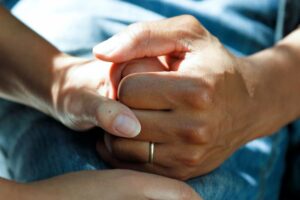 Cogidos de la mano sobre una cama de hospital