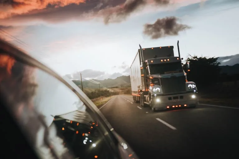 Truck overtaking a car on dimly lit road