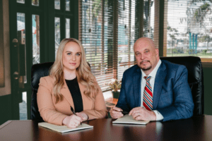 La imagen muestra a los abogados de lesiones personales Kevin R. Hansen y Amanda A. Harmon, sentados en una mesa de conferencias en la oficina de Las Vegas.